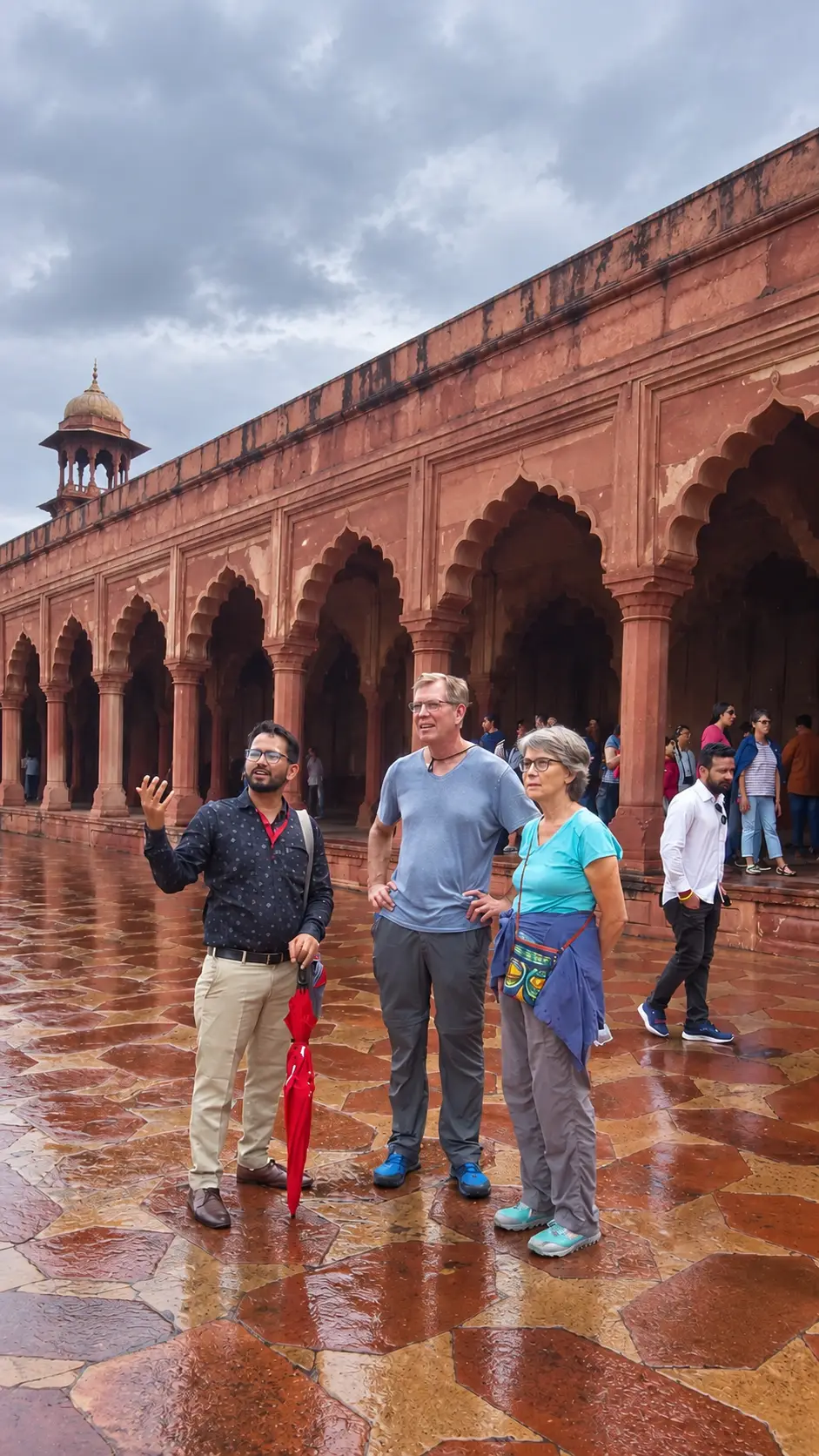 Tour guide Ali Khan showing tourists Agra Fort after rain in Agra, India