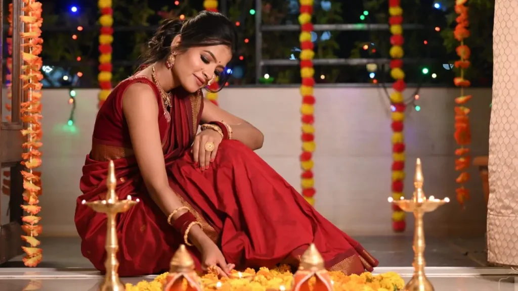 Cultures of India: Exploring the Soul of a Timeless Civilization 4 A woman in a traditional red saree lighting diyas and decorating with marigold flowers during Diwali, celebrating India's Festival of Lights and cultural traditions.