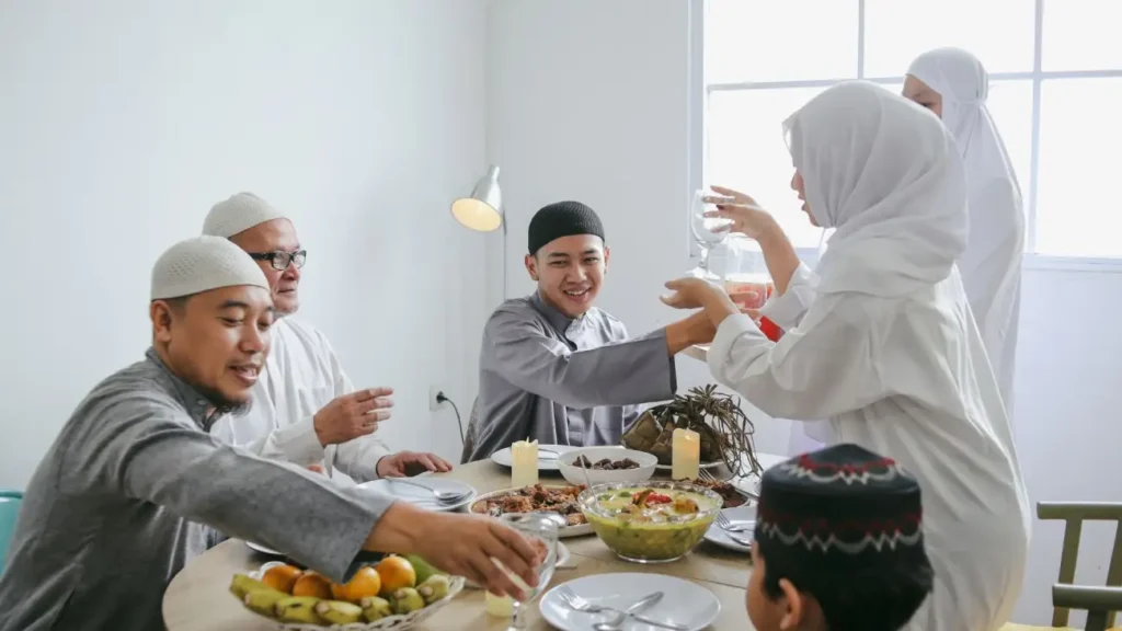 Cultures of India: Exploring the Soul of a Timeless Civilization 7 A Muslim family gathered around a dining table sharing a festive meal during Eid, reflecting India's traditions of togetherness, hospitality, and cultural diversity.
